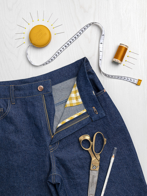 Learn to Sew Jeans class by Closet Core Patterns, dark denim jeans with open fly, gingham pocketing, scissors and tape measure.