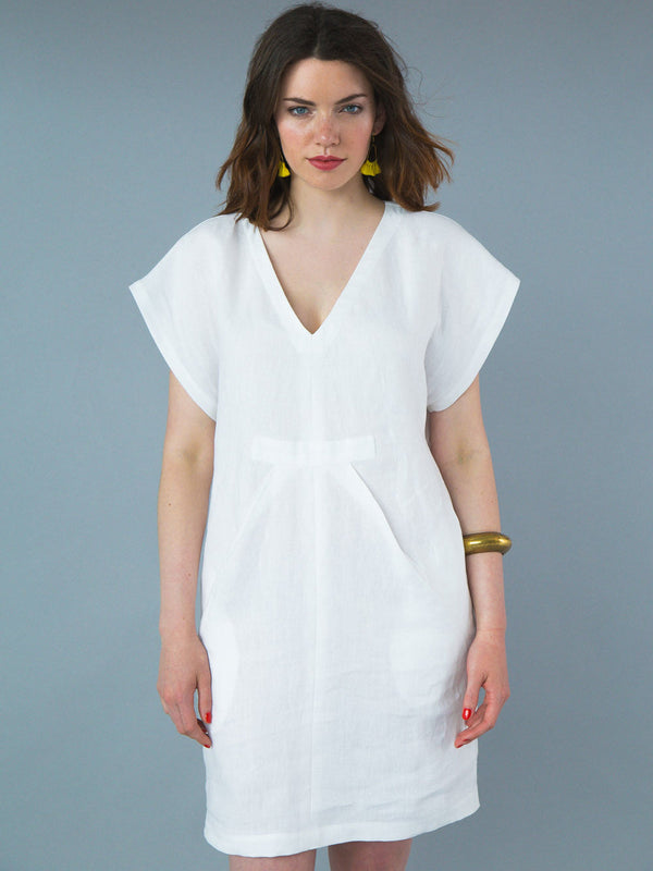 Sewn sample of the Charlie caftan sewing pattern by Closet Core Patterns in white linen, front view with V neckline and pleats.