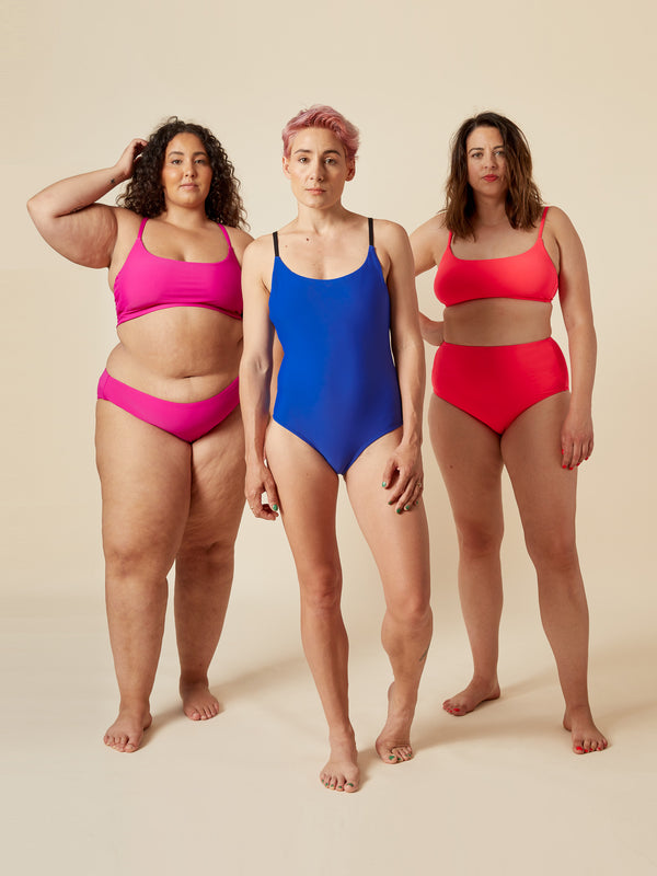Sewn sample of the Faye swimsuit sewing pattern by Closet Core Patterns in magenta, blue and red, bikinis and a one-piece, front view.