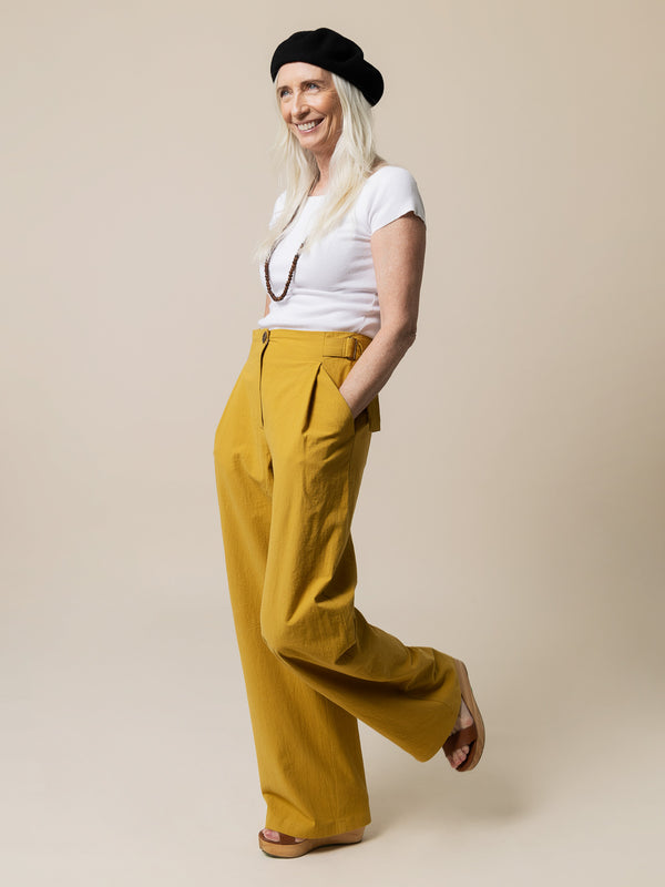 Sewn sample of the Mitchell trouser sewing pattern by Closet Core Patterns in mustard yellow with front pleats and side tab.